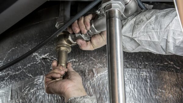 Fontanero instalando la tubería de entrada de un sistema de tratamiento de agua doméstico