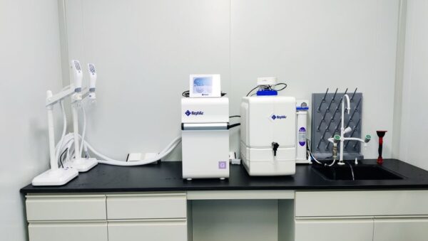Equipo de purificación de agua con depósito, grifo y fregadero de desagüe en un laboratorio